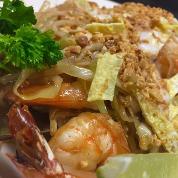 Stir Crazy's shrimp pad thai with noodles, eggs, peanuts, and a lime wedge.