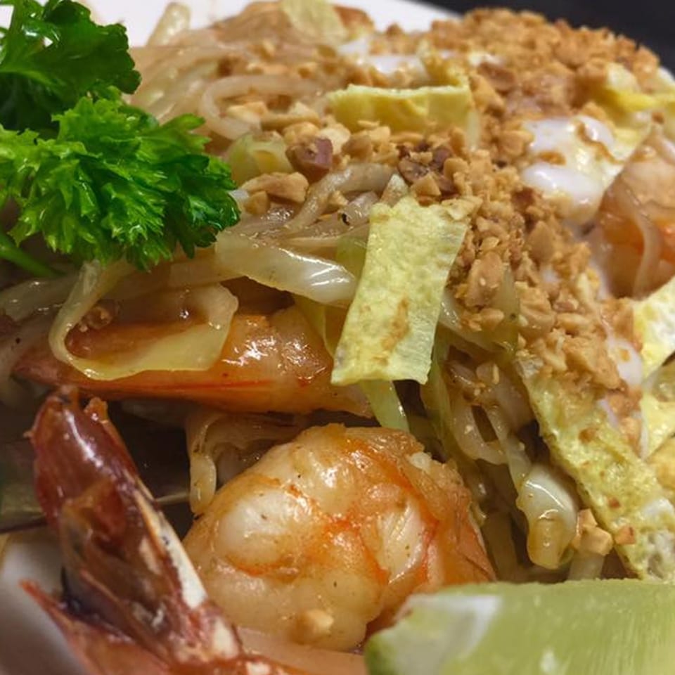 Stir Crazy's shrimp pad thai with noodles, eggs, peanuts, and a lime wedge.