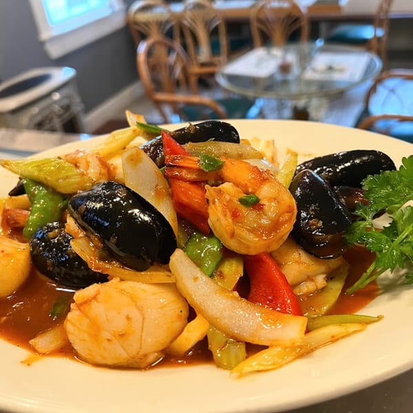 Stir Crazy's Asian-fusion seafood dish with mussels, shrimp, scallops, and colorful vegetables in sauce.