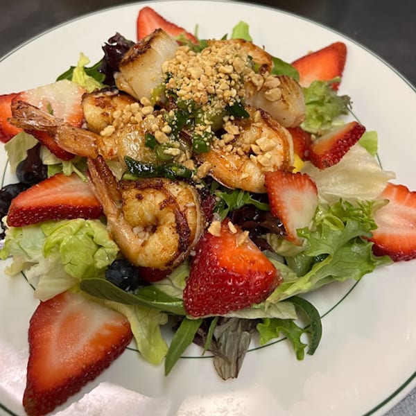 Stir Crazy's Asian-fusion salad with grilled shrimp, scallops, strawberries, and peanuts on mixed greens.